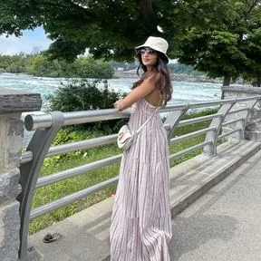 Akshita in a white bucket hat by the river at Niagara